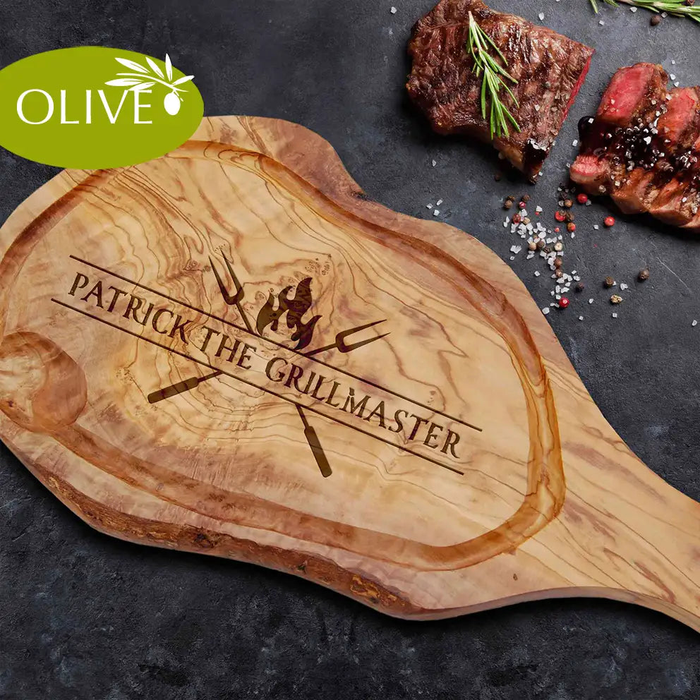 Motiv THE GRILLMASTER - Mediterranes Schneidebrett aus Olivenholz mit Handgriff & Saftrille und personalisierten Gravurmotiv - Jeske Design