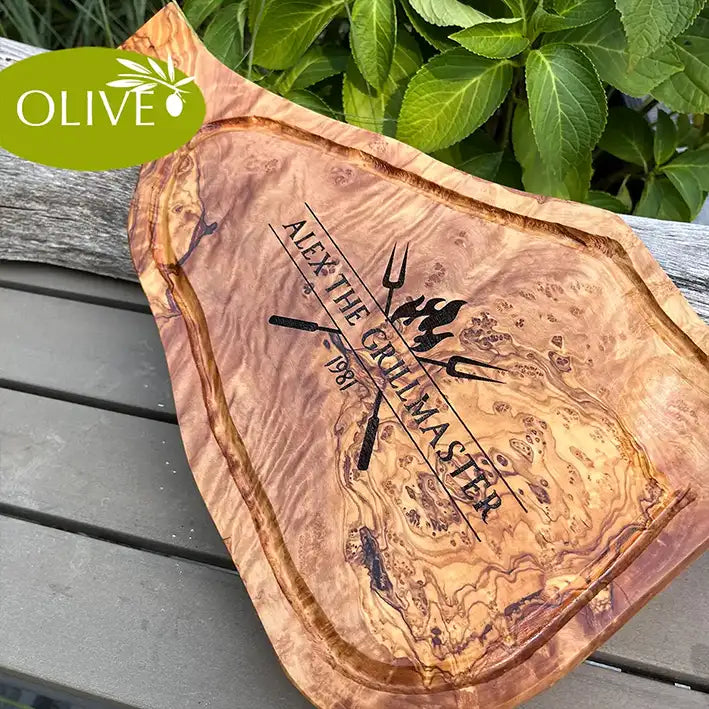 Motiv THE GRILLMASTER - Mediterranes Schneidebrett aus Olivenholz mit handgriff und Saftrille und personalisierten Gravurmotiv - Jeske Design