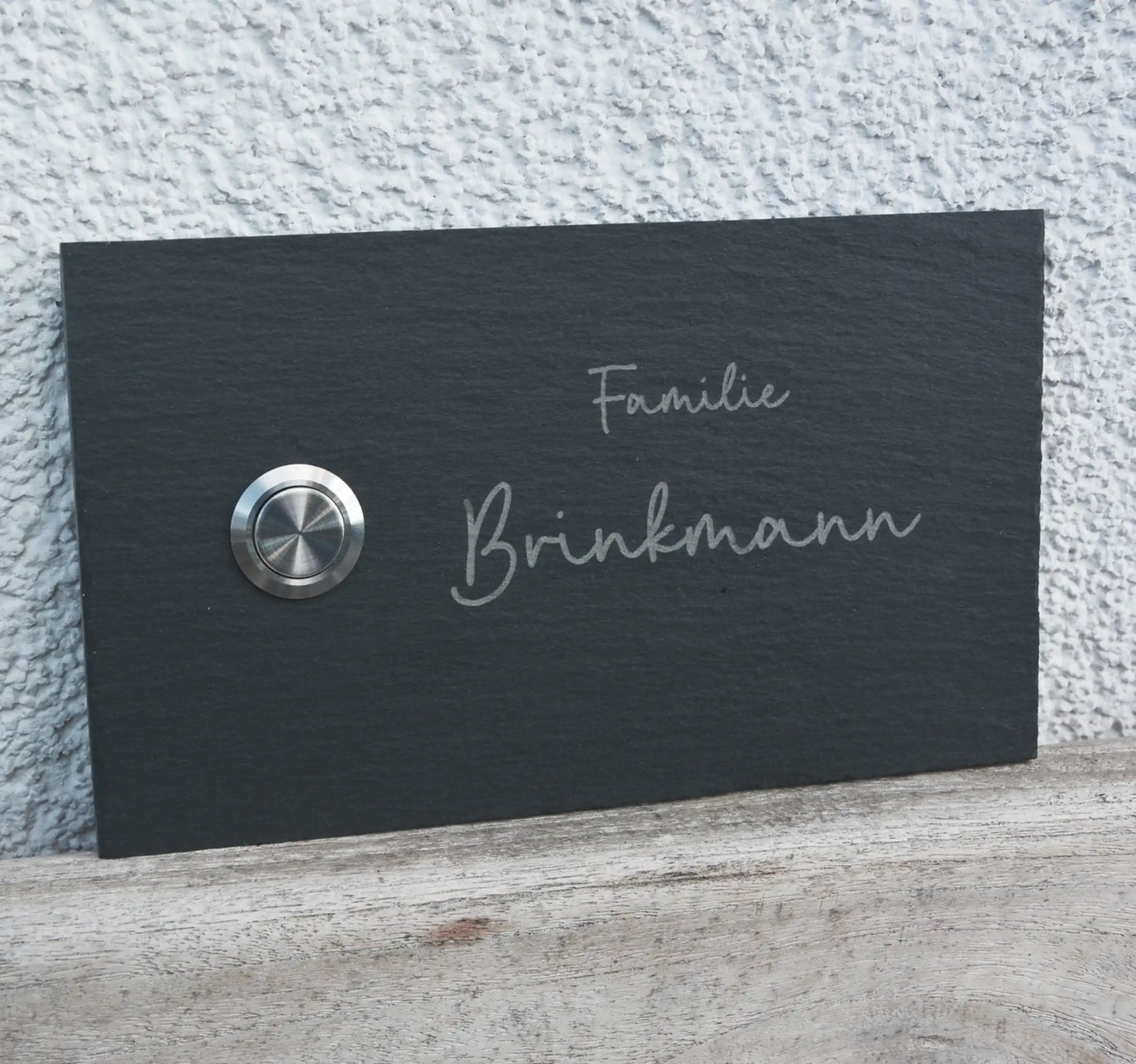 Klingelschild aus Schiefer mit geschnittenen Kanten in 17x10cm Längsformat Edelstahltaster unbeleuchtet linksseitig. Familienname mit Handschrift zweizeilig
