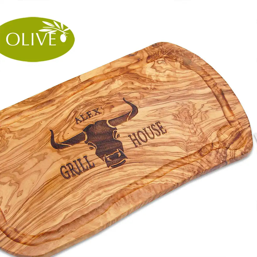 Motiv GRILL HOUSE mit Wunschnamen und stilisiertem Rinderkopf von vorne - Mediterranes Schneidebrett aus Olivenholz mit Saftrille und personalisierten Gravurmotiv - Jeske Design