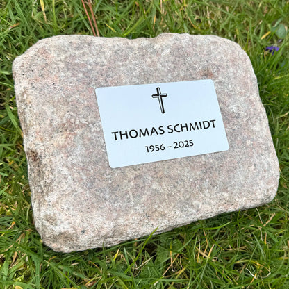 Kleiner Granitstein mit Metallplättchen für Gedenkstein in Seitenansicht