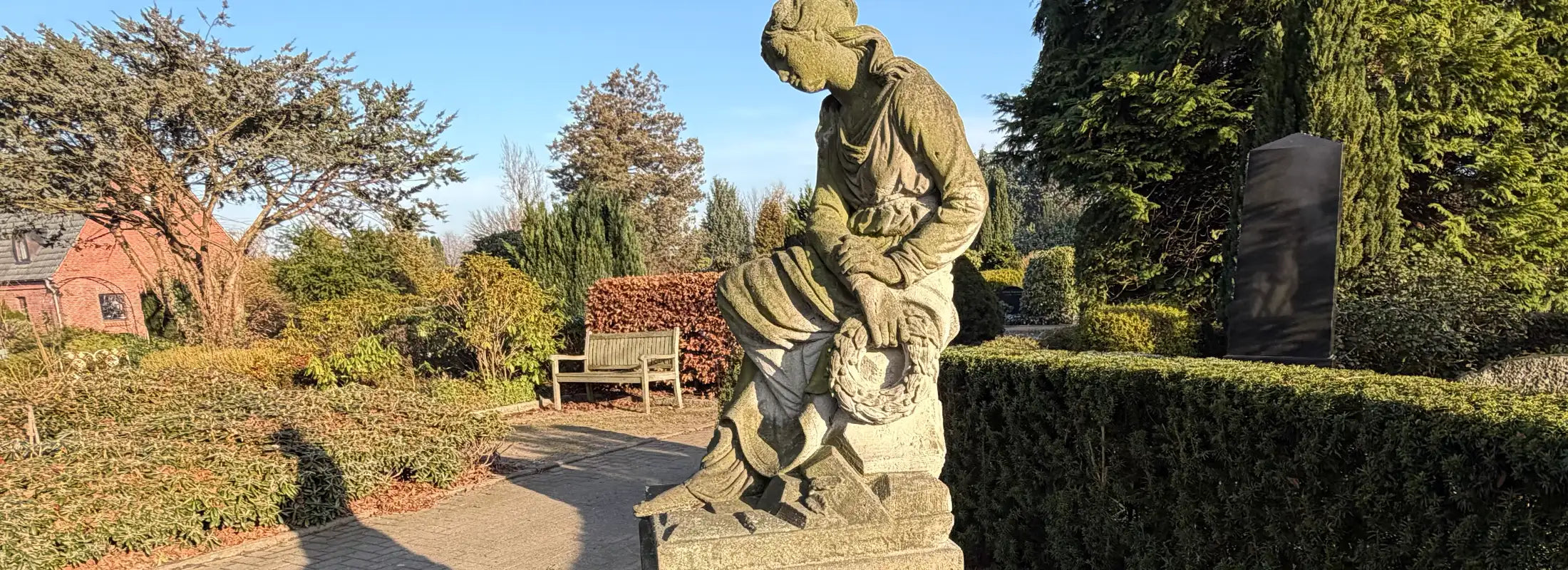 Sandsteinskuptur einer jungen sitzenden Dame auf dem Friedhof
