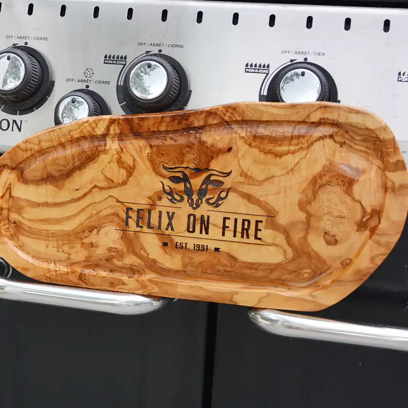 Motiv "On Fire" mit stilisiertem Rinderkopf mit Flammen und  Personaliserungsoption mit Name in Großbuchstaben und Datum - Mediterranes Schneidebrett aus Olivenholz mit Saftrille mit und ohne Grifflasche oder Handgriff - Personalisiertes Männergeschenk von Jeske Design