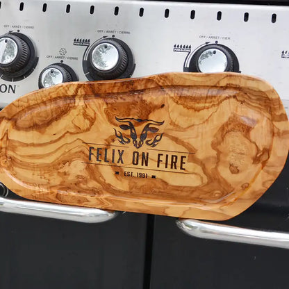 Motiv "On Fire" mit stilisiertem Rinderkopf mit Flammen und  Personaliserungsoption mit Name in Großbuchstaben und Datum - Mediterranes Schneidebrett aus Olivenholz mit Saftrille mit und ohne Grifflasche oder Handgriff - Personalisiertes Männergeschenk von Jeske Design