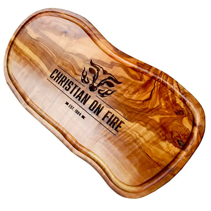 Motiv "On Fire" mit stilisiertem Rinderkopf mit Flammen und  Personaliserungsoption mit Name in Großbuchstaben und Datum - Mediterranes Schneidebrett aus Olivenholz mit Saftrille mit und ohne Grifflasche oder Handgriff - Personalisiertes Männergeschenk von Jeske Design