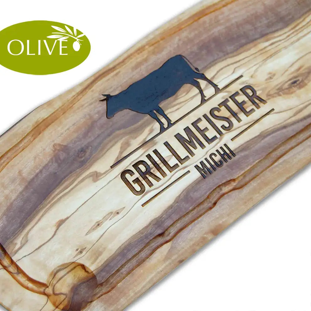 Motiv GRILLMEISTER mit Wusnchnamen und stilisiertem Rind - Mediterranes Schneidebrett aus Olivenholz mit Saftrille und personalisierten Gravurmotiv - Jeske Design