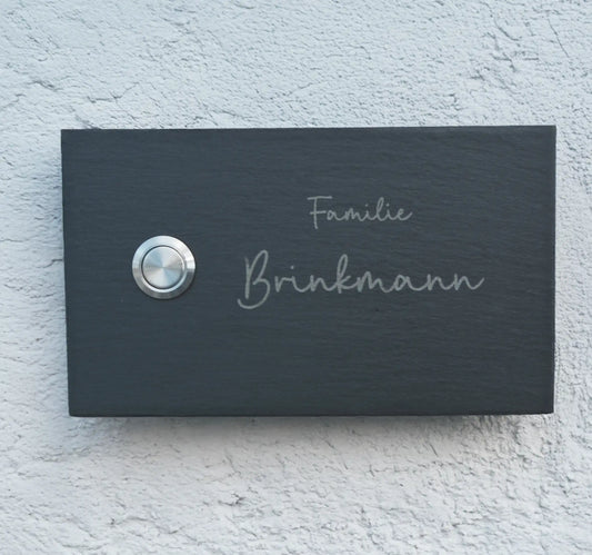 Klingelschild aus Schiefer mit geschnittenen Kanten in 17x10cm Längsformat Edelstahltaster unbeleuchtet linksseitig. Familienname mit Handschrift zweizeilig