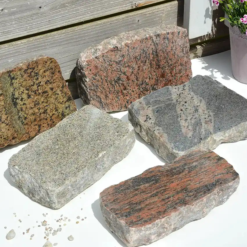 Verschiedene Naturstein Blöcke geschnitten Granit rot meliert und grau meliert