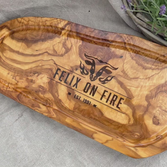 Motiv "On Fire" mit stilisiertem Rinderkopf mit Flammen und  Personaliserungsoption mit Name in Großbuchstaben und Datum - Mediterranes Schneidebrett aus Olivenholz mit Saftrille mit und ohne Grifflasche oder Handgriff - Personalisiertes Männergeschenk von Jeske Design