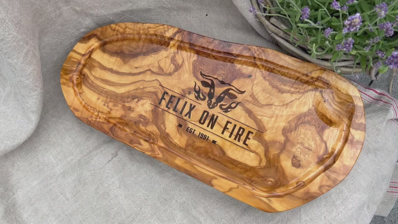 Motiv "On Fire" mit stilisiertem Rinderkopf mit Flammen und  Personaliserungsoption mit Name in Großbuchstaben und Datum - Mediterranes Schneidebrett aus Olivenholz mit Saftrille mit und ohne Grifflasche oder Handgriff - Personalisiertes Männergeschenk von Jeske Design